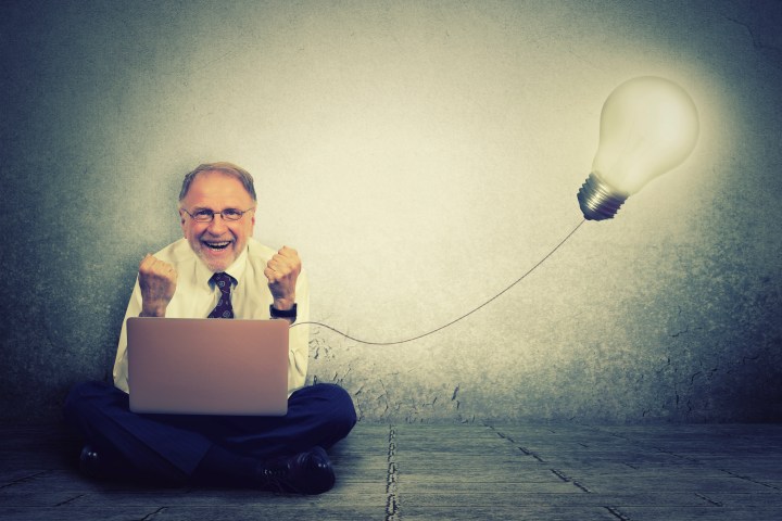 Man working on computer with light bulb plugged in it