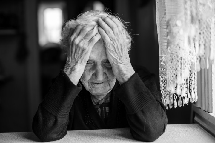 Elderly woman sitting at the table in a depressed state,